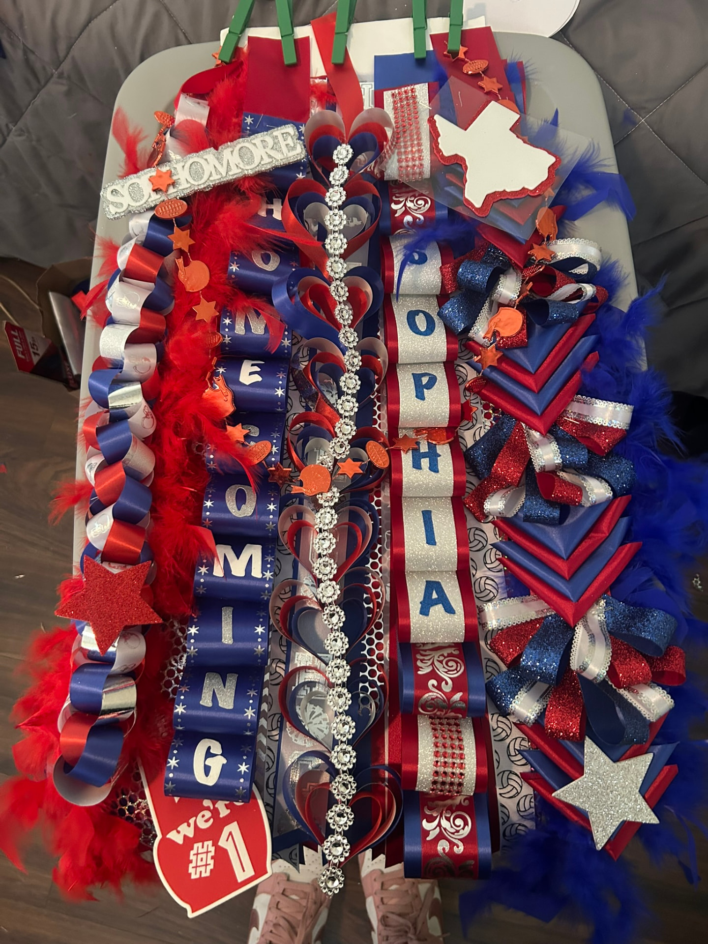 Elaborate homecoming mum with SOPHIA name, red and blue ribbons and football charms