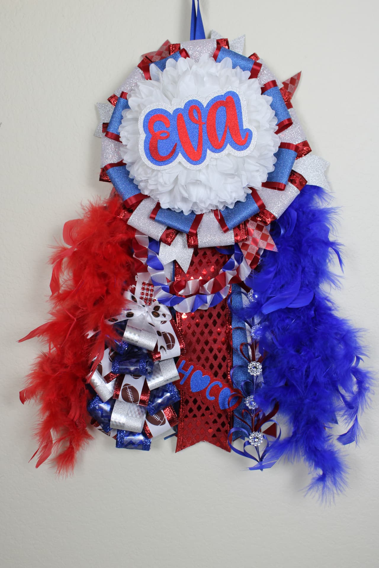 Elaborate senior homecoming mum with EVA name, red and blue feather boas